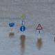 Verkehrsschilder die gerade so aus dem Hochwasser rausschauen